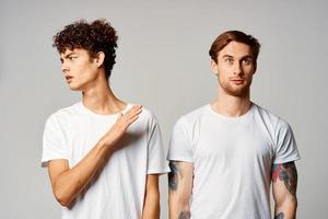 deux homme dans blanc t-shirts sont permanent suivant à relation amicale émotions photo