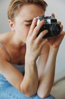 femme photographe tournage dans studio sur vieux film caméra à Accueil sur canapé portrait, blanc arrière-plan, gratuit copie espace, free-lance photographe photo