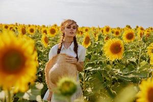 femme avec nattes à la recherche dans le tournesol champ paysage photo