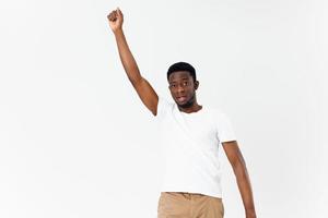 homme africain apparence blanc T-shirt tenir le sien main au dessus le sien tête lumière Contexte photo