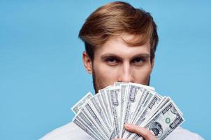 homme en portant liasse de argent près visage richesse fermer studio photo