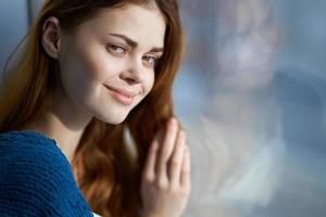 magnifique femme séance sur le rebord de fenêtre avec une bleu plaid sourire photo