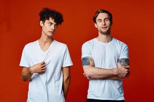 deux Hommes dans blanc t-shirts supporter suivant à la communication rouge Contexte photo