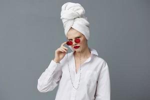 glamour femme avec une serviette sur le sien tête dans une blanc chemise isolé Contexte photo