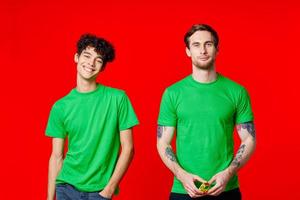 deux copains sont permanent côté par côté dans vert t-shirts avec des lunettes photo