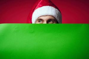émotif homme dans une Noël chapeau avec vert maquette studio posant photo