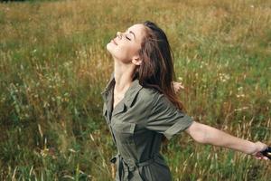 femme dans vert combinaison avec fermé yeux profiter liberté photo