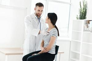 Masculin médecin dans blanc manteau examiner patient dans hôpital photo