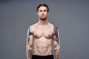 sportif homme avec tatouages sur le sien bras faire des exercices tondu vue photo