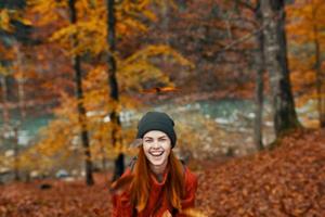 content femme promeneur dans le l'automne forêt près le rivière faire des gestes avec sa mains copie espace photo