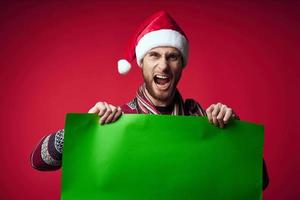 Beau homme dans une Noël chapeau avec vert maquette rouge Contexte photo