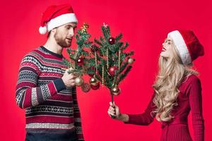 homme et femme avec des arbres dans leur mains vacances jouets décoration rouge Contexte photo