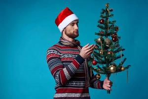 émotif homme dans une Père Noël chapeau en portant une bannière vacances bleu Contexte photo