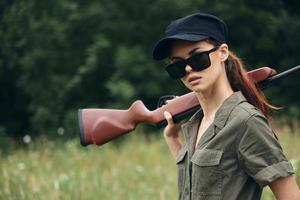 femme sur la nature des lunettes de soleil fusil à pompe chasse mode de vie vert feuilles photo