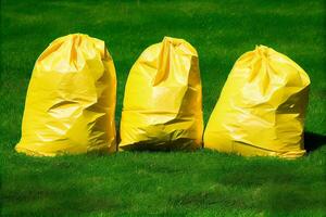 Jaune des ordures Sacs sur le herbe illustration génératif ai photo