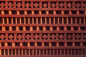 rouge brique mur avec ornemental modèle dans ombre et lumière pente photo