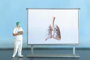 miniature personnes. une médecin examine pneumonie dans le image, une respiratoire maladie. photo