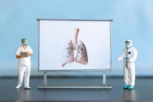 miniature personnes. une médecin examine pneumonie dans le image, une respiratoire maladie. photo