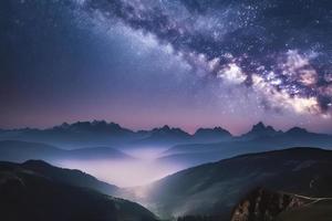 laiteux façon plus de montagnes dans brouillard à nuit dans été. paysage avec brumeux alpin Montagne vallée photo