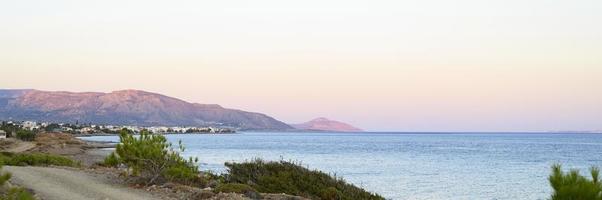 paysage marin au crépuscule avec des montagnes de fond photo