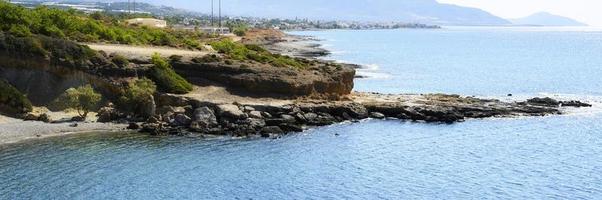 beau lagon bleu avec eau de mer claire et plage de galets et rochers photo