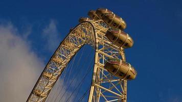 ferris roue dans le amusement parc sur Contexte de bleu ciel avec des nuages. faible angle vue de une gros ferris roue. photo