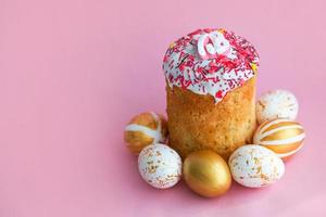 Pâques Gâteaux - traditionnel kulich et d'or des œufs sur une rose Contexte. paska Pâques pain dans russe des lettres xb photo