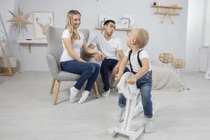 famille. papa maman enfant jouer à maison. mari épouse et peu fils. couple avec bébé dans le appartement photo