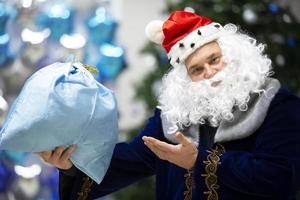 Père Noël claus homme points à une sac avec une cadeau.noel vacances. photo