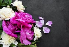 Fleurs de pivoine sur fond de béton noir photo