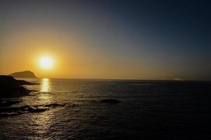 magnifique le coucher du soleil par le mer photo