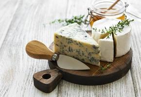 divers types de fromage, fromage bleu, brie, camembert et miel sur une table en bois