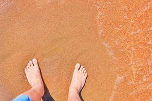 les pieds de l'homme sur la plage photo