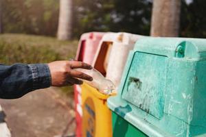 dumping des ordures bouteilles dans le poubelle photo