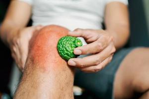 Hommes avec le genou douleur utilisation bergamote herbes à soulager. photo