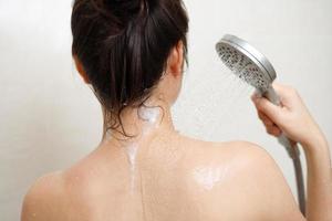 femme prise une douche, baignade dans le salle de bains photo