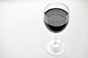 Grand verre de vin rouge sur fond blanc photo