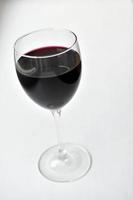 Grand verre de vin rouge sur fond blanc photo