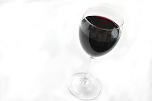 Grand verre de vin rouge sur fond blanc