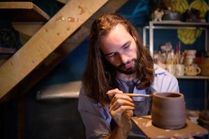 poterie artiste, Jeune fabrication une pièce de argile moulage calmement et méticuleusement dans commande à produire le plus attrayant travail possible, photo