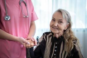 soignant pour un personnes âgées femme hebdomadaire contrôles à le les patients résidence. prêt à donner médical Conseil et parler à propos divers histoires, échange chaque autre Heureusement. photo