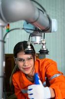 dans un électronique les pièces facilité, femelle ingénieurs dans le usine, inspecter et essai robotique mains utilisé dans le production de électronique Composants. photo