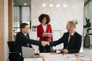 affaires gens tremblement mains pendant une réunion dans moderne Bureau photo