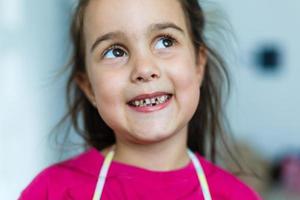 peu fille est tombée une bébé dent. enfant bouche avec trou entre le dents. peu profond département de champ photo