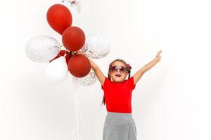 peu fille avec des ballons sur une blanc Contexte photo