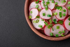 délicieux Frais salade de tranché des radis avec vert oignons, sel et olive pétrole photo