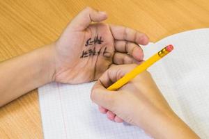 étudiant écrit de le tester de le Tricher feuille écrit sur le main. photo
