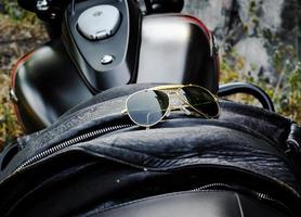 lunettes de soleil sur une veste en cuir sur un siège de moto photo