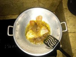 poisson cette est étant frit en utilisant pétrole dans une cuisine pot photo