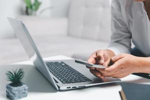 social médias journée concept. femelle pigiste départ travail journée de bonne heure dans vivant pièce pour site Internet avec téléphone intelligent. femme d'affaires travail dans Accueil bureau. femme communicant avec en ligne technologie. photo